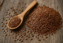 بذور الكتان | Flaxseed صورة واقعية لبذور الكتان مع ملعقة خشبية على خلفية طبيعية.